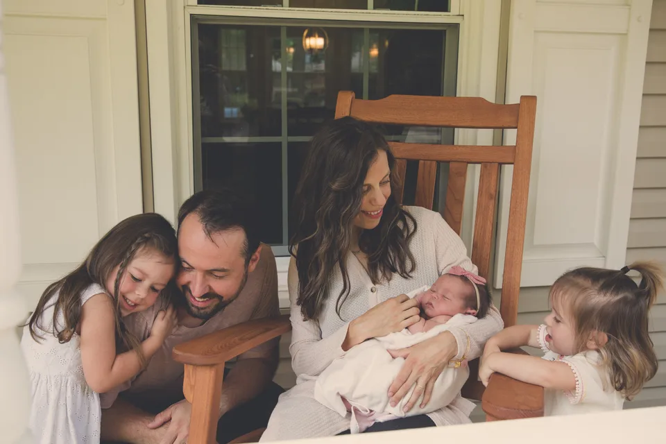 A family with their newborn on the porch